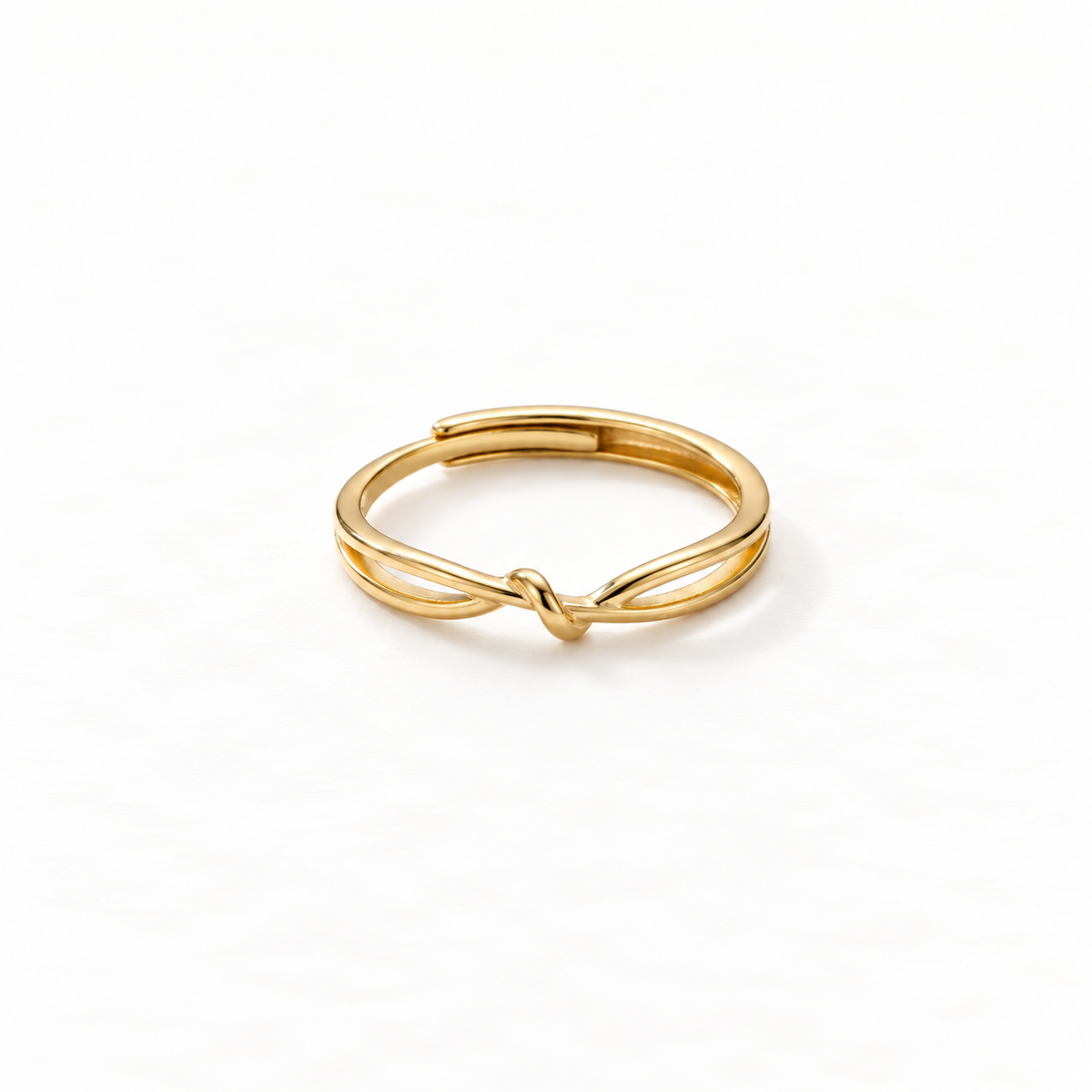 A gold infinity knot ring with continuous loop design forming a figure-eight love knot, delicate open adjustable band with twisted center detail, shown from front and side angles on a clean white background displaying the eternal connection symbolism, sleek interwoven form, and polished gold finish.