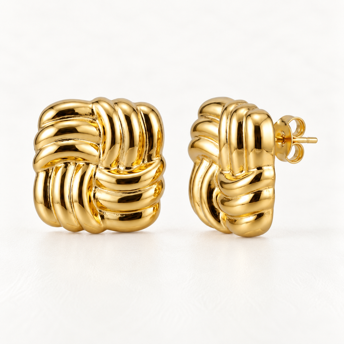 A pair of 18k gold knot-braid stud earrings with interwoven square woven texture, shown from front and side angles on a clean white background displaying the detailed braided pattern and post with butterfly backing.