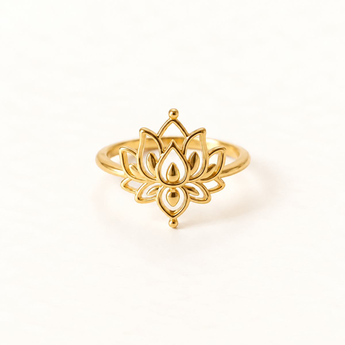 A gold lotus flower ring with detailed layered petal design and central teardrop accent, open adjustable band, shown from front and side angles on a clean white background displaying the intricate botanical symbolism, spiritual bloom form, and polished gold finish.