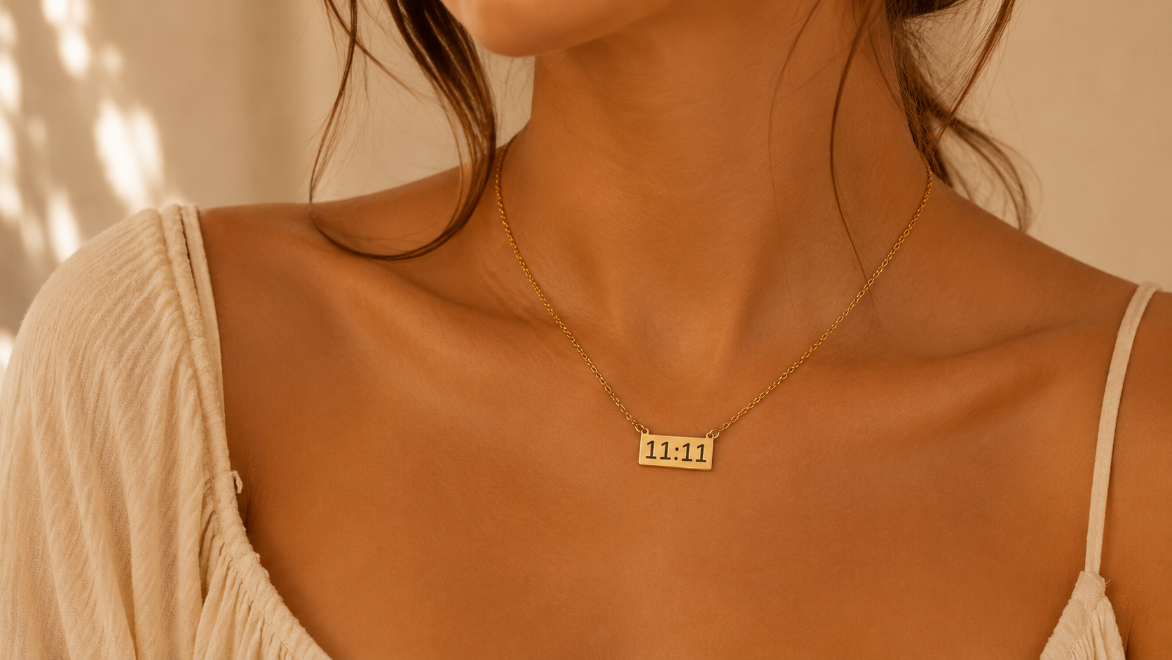 Close-up of gold 11:11 necklace on model with warm golden lighting and soft neutral minimalist aesthetic.