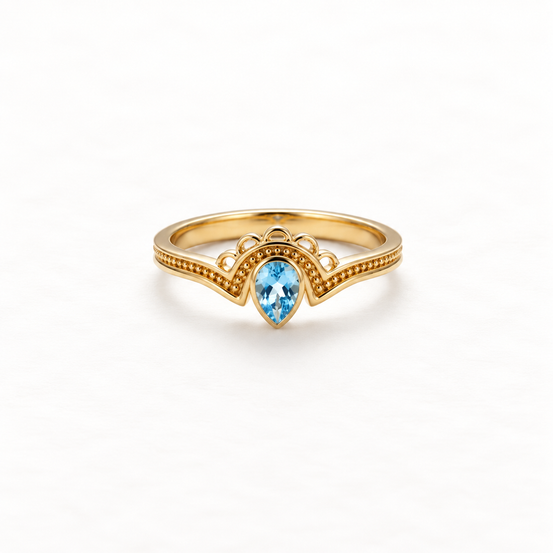 A gold aquamarine teardrop ring with pear-shaped blue stone in vintage-inspired milgrain setting, delicate beaded band detail and scalloped edges, open adjustable design, shown from front and side angles on a clean white background displaying the soft blue hue, intricate metalwork, and polished gold finish.