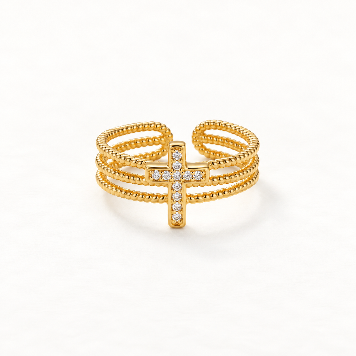 A gold beaded cross pave ring with three rows of ball chain bands and crystal-encrusted cross centerpiece, delicate open adjustable design, shown from front and side angles on a clean white background displaying the sparkling stone detail, textured beaded texture, and polished gold finish.