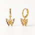 A pair of 18k gold huggie hoop earrings with dangling butterfly charms covered in multicolored pave crystals, shown from front and side angles on a clean white background displaying the vibrant rainbow stone detail and hinged closure.