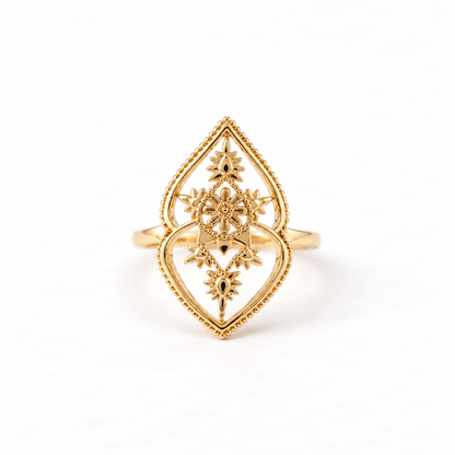 A gold celestial mandala ring with intricate filigree geometric pattern inside diamond-shaped frame, starburst center with radiating details, open adjustable band, shown from front and side angles on a clean white background displaying the ornate sacred geometry, delicate metalwork, and polished gold finish.