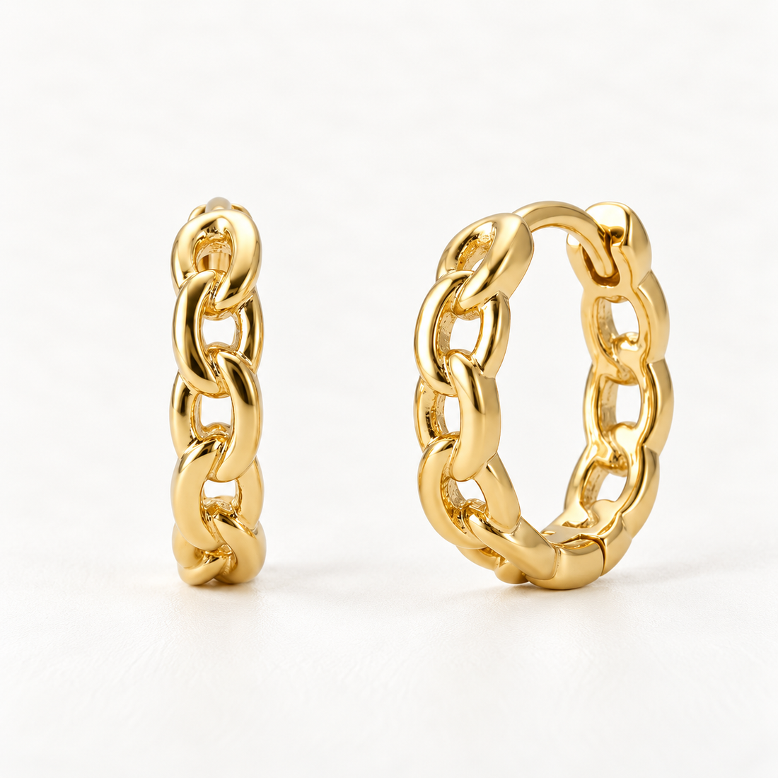 A pair of 18k gold chain-link huggie hoop earrings with interlocking oval chain pattern, shown from front and side angles on a clean white background displaying the detailed link texture and hinged closure.