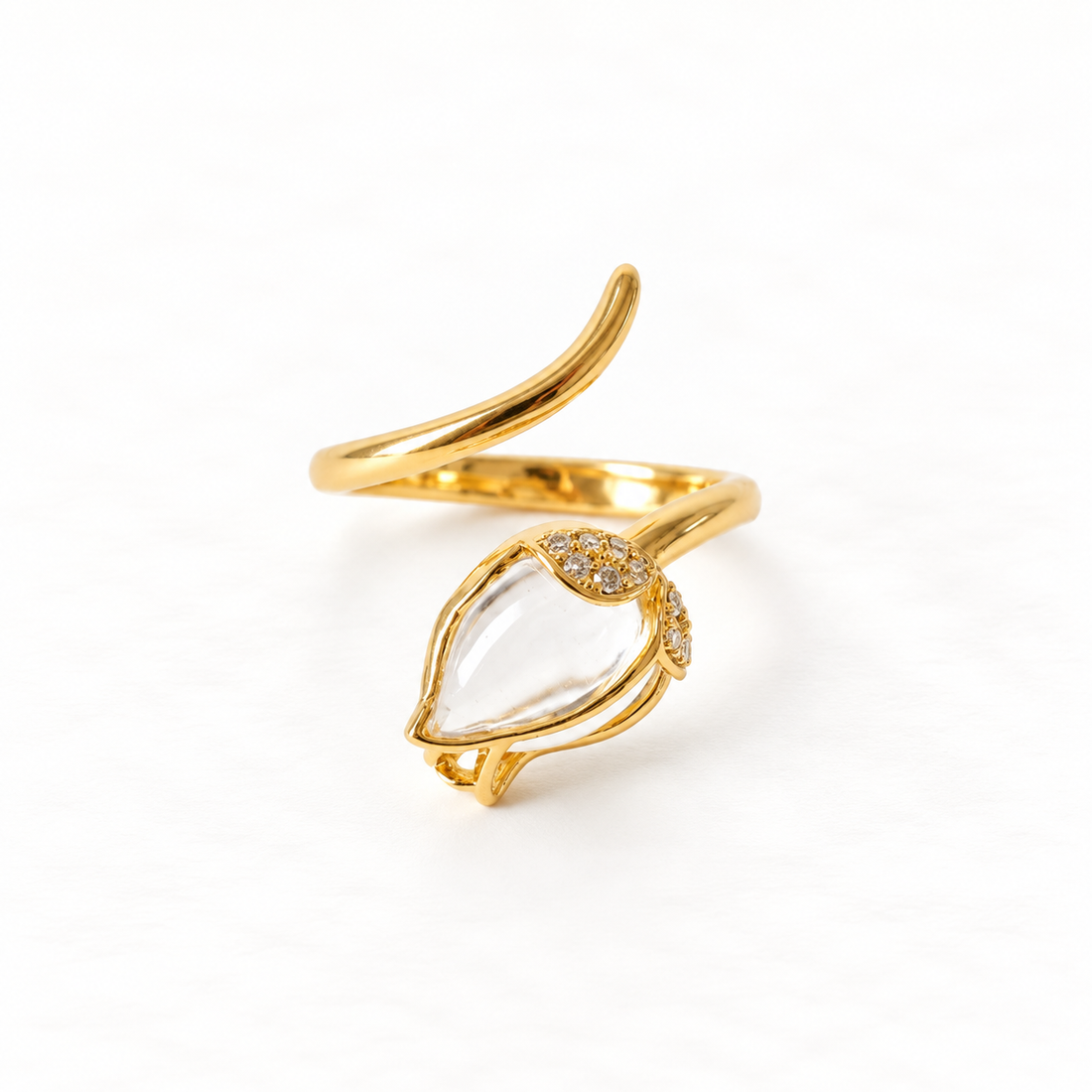 A gold clear crystal teardrop ring with marquise-shaped clear quartz stone in delicate prong setting, small accent stones on band, open adjustable design, shown from front and side angles on a clean white background displaying the transparent clarity, elegant minimal setting, and polished gold finish.