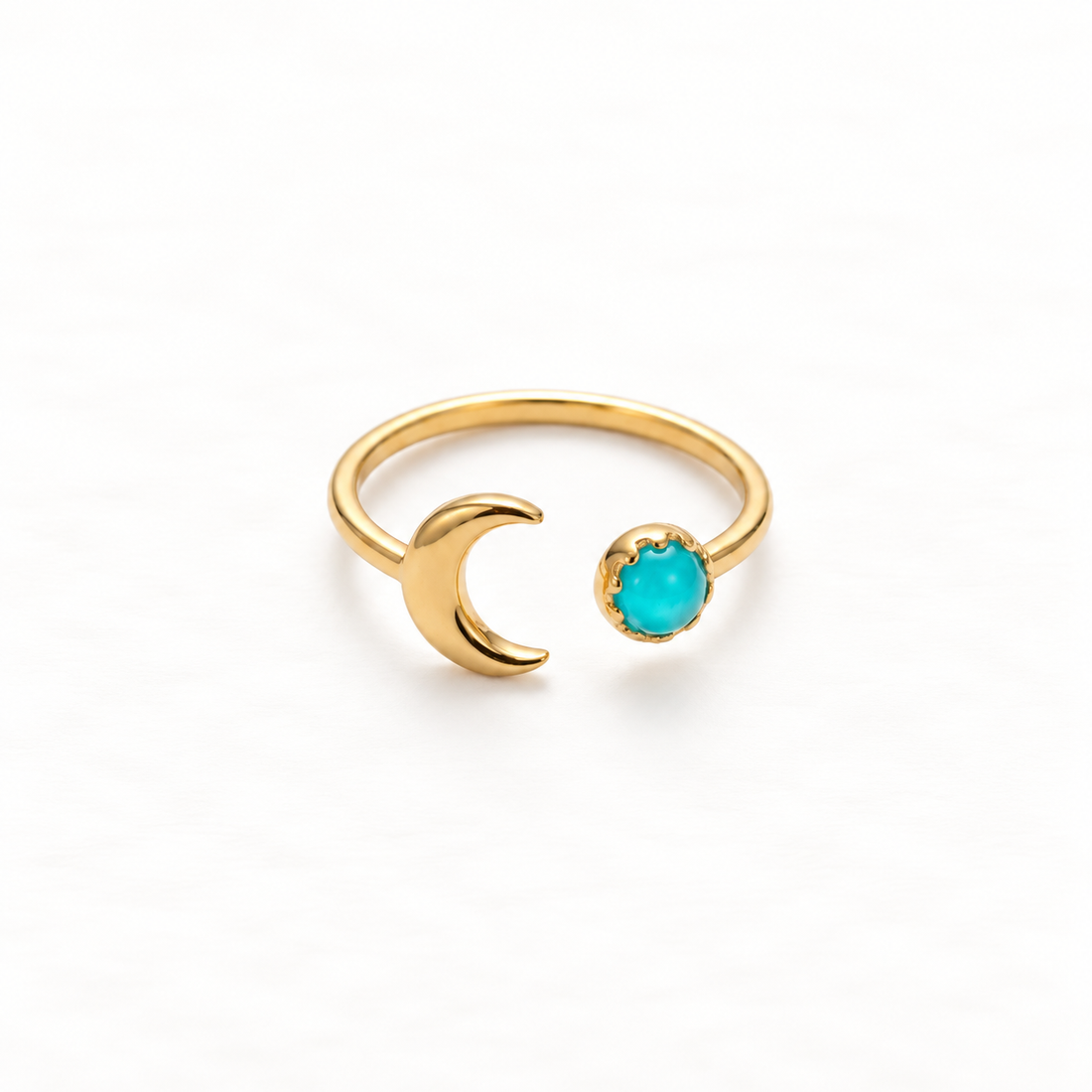 A gold crescent moon turquoise ring with curved moon silhouette and round vibrant turquoise stone on open adjustable band, celestial design with two terminal elements, shown from front and side angles on a clean white background displaying the bright blue-green hue, lunar symbolism, and polished gold finish.