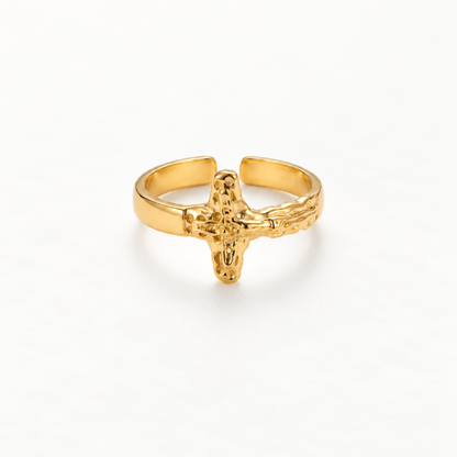 A gold crucifix cross ring with detailed textured 3D cross design and organic hammered band, open adjustable religious statement piece, shown from front and side angles on a clean white background displaying the sculptural crucifix form, intricate surface texture, and polished gold finish.