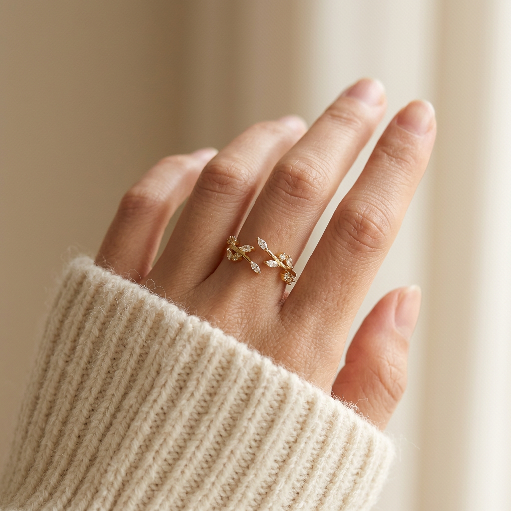 Close-up of a feminine hand wearing a gold crystal vine ring with winding branch design and clear pave stones, the nature-inspired sparkle resting on the finger. Soft natural lighting, warm beige linen background, natural skin texture with visible pores and slight imperfections.
