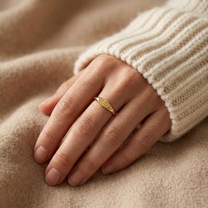 Close-up of a feminine hand wearing a gold angel number ring with "11:11" engraved on the band, the spiritual synchronicity symbol visible on the finger. Soft natural lighting, warm beige linen background, natural skin texture with visible pores and slight imperfections.