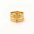 A gold face ring with surrealist facial features including eyes, nose, and mouth across stacked bands, open adjustable design, shown from front and side angles on a clean white background displaying the artistic anthropomorphic detail, sculptural expression, and polished gold finish.