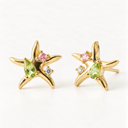 A pair of 18k gold starfish-shaped stud earrings with green peridot and pink tourmaline gemstones, shown from front and side angles on a clean white background displaying the colorful sea-inspired stone detail and post with butterfly backing.