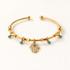A gold Hamsa hand bracelet with turquoise blue beads and central Hamsa charm featuring evil eye detail, shown from front and side angles on a clean white background displaying the delicate chain links, adjustable ball ends, and spiritual charm design.