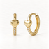 A pair of 18k gold huggie hoop earrings with polished heart charms on the front and clear pave crystals along the hoop, shown from front and side angles on a clean white background displaying the sparkling stone detail and hinged closure.
