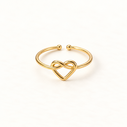 A gold infinity heart ring with continuous loop forming an intertwined heart shape, open adjustable band with textured rope detail, shown from front and side angles on a clean white background displaying the eternal love symbolism, delicate interwoven design, and polished gold finish.