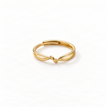 A gold infinity knot ring with continuous loop design forming a figure-eight love knot, delicate open adjustable band with twisted center detail, shown from front and side angles on a clean white background displaying the eternal connection symbolism, sleek interwoven form, and polished gold finish.