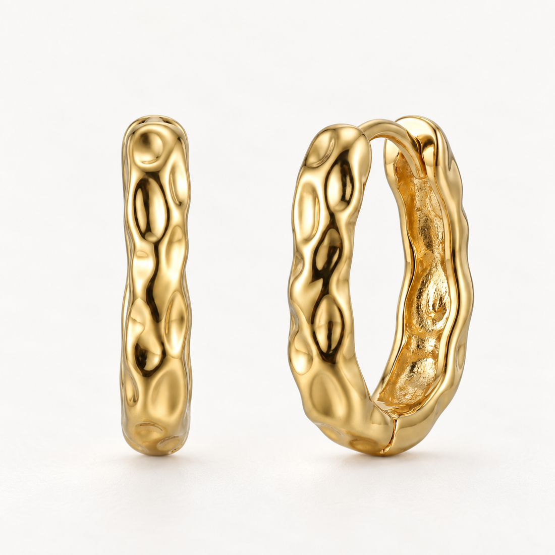 A pair of 18k gold lava-textured huggie hoop earrings with organic bumpy molten surface, shown from front and side angles on a clean white background displaying the irregular bubble-like detail and hinged closure.