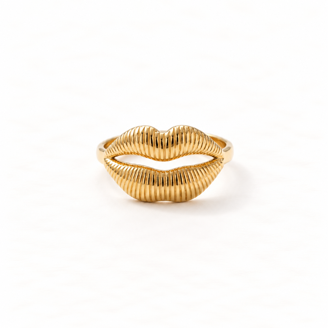 A gold lips kiss ring with detailed puckered mouth design and textured lip lines, playful statement piece with open adjustable band, shown from front and side angles on a clean white background displaying the sculptural mouth form, intricate lip texture, and polished gold finish.