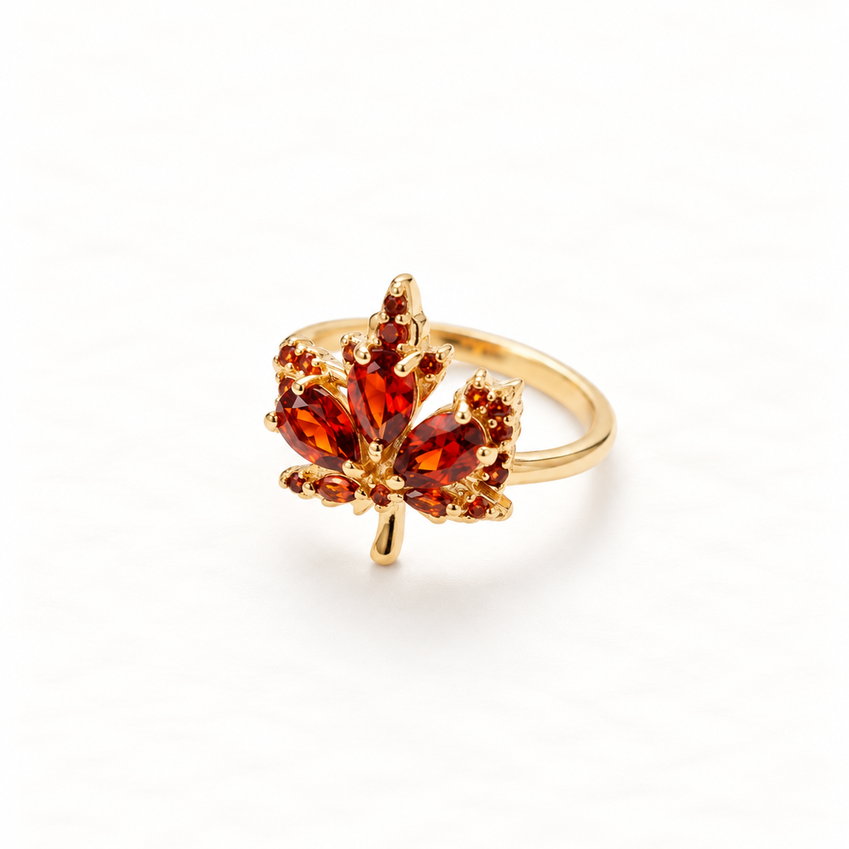 A gold maple leaf ring with amber orange citrine stones set in detailed leaf formation, autumn-inspired design with veined texture, open adjustable band, shown from front and side angles on a clean white background displaying the warm fall hues, intricate stone setting, and polished gold finish.