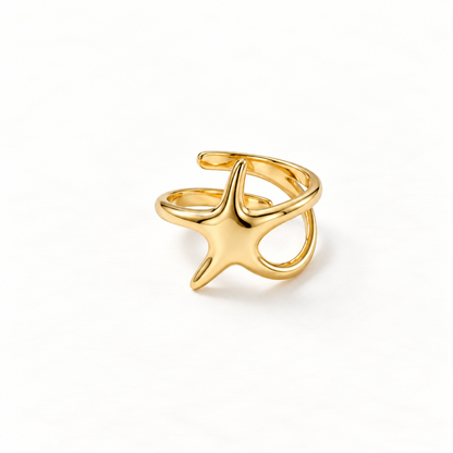 A gold starfish ring with five-pointed sea star shape and textured surface detail, open adjustable band with organic marine form, shown from front and side angles on a clean white background displaying the nautical beach aesthetic, intricate star texture, and polished gold finish.