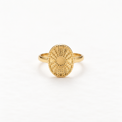 A gold sun coin filigree ring with intricate radiating pattern and smooth polished center, detailed metalwork sunburst design, open adjustable band, shown from front and side angles on a clean white background displaying the ornate celestial symbolism, delicate ray texture, and polished gold finish.