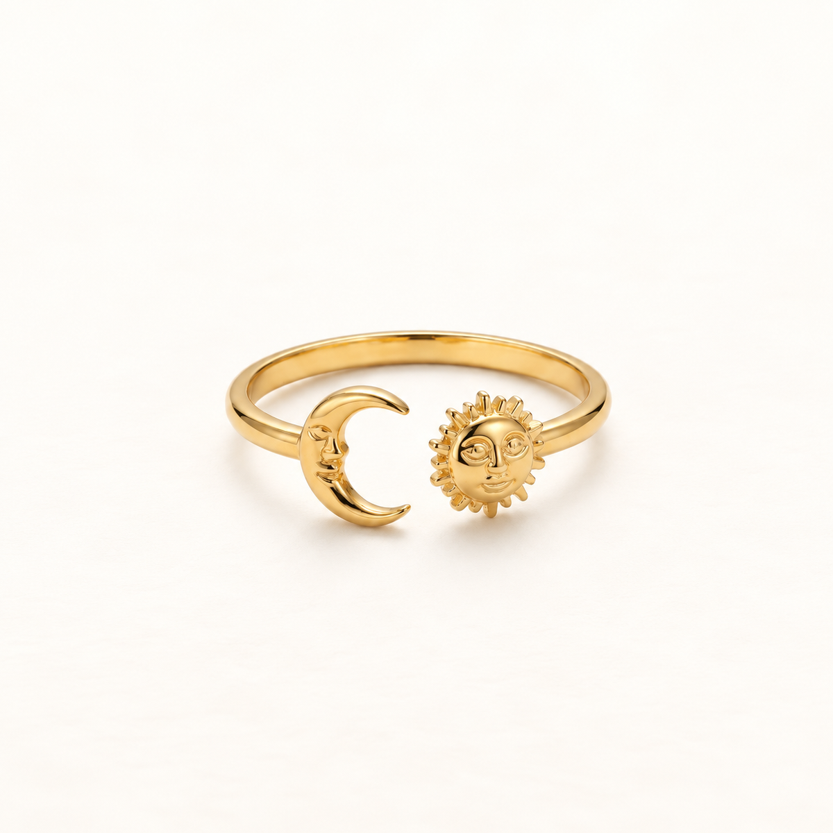 A gold sun and moon open ring with anthropomorphic sun face and crescent moon charms, detailed facial features and radiating rays on sun, shown from front and side angles on a clean white background displaying the adjustable open band, celestial symbolism, and polished gold finish.