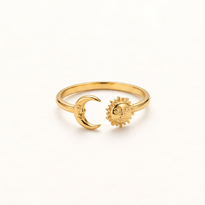 A gold sun and moon open ring with anthropomorphic sun face and crescent moon charms, detailed facial features and radiating rays on sun, shown from front and side angles on a clean white background displaying the adjustable open band, celestial symbolism, and polished gold finish.