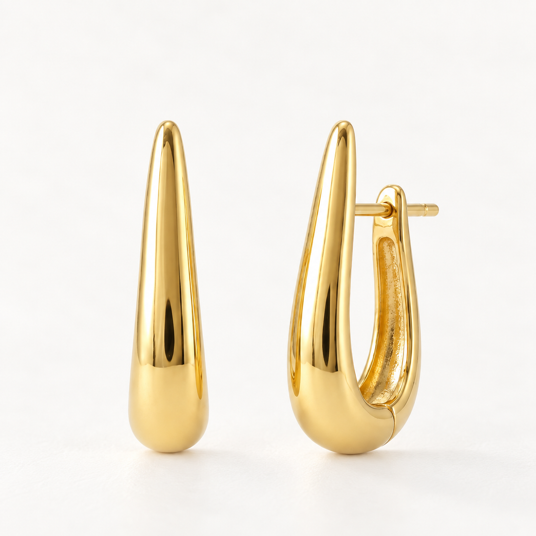 A pair of 18k gold teardrop-shaped huggie hoop earrings with elongated sleek polished profile, shown from front and side angles on a clean white background displaying the smooth reflective surface and hinged closure.