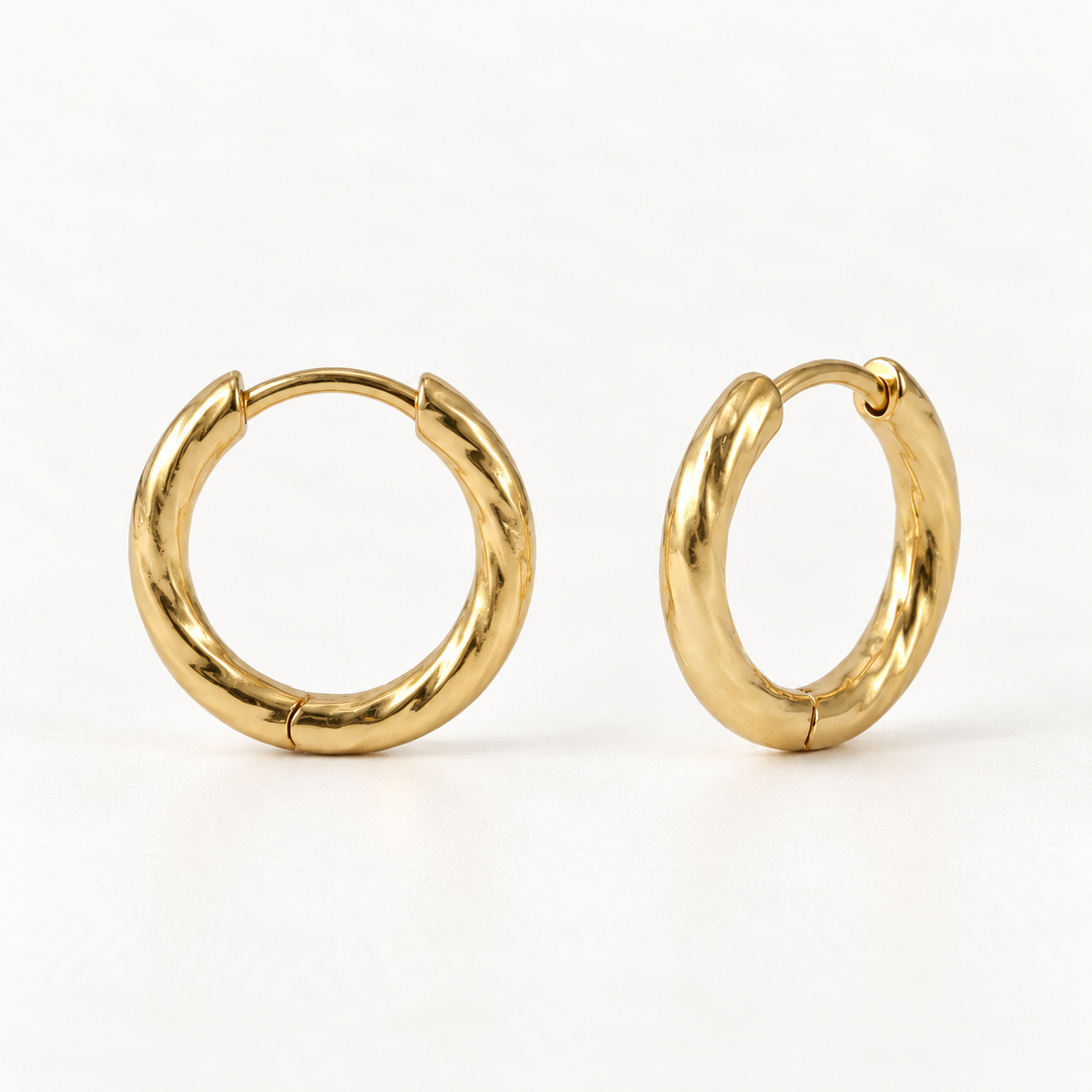 A pair of 18k gold twisted rope huggie hoop earrings with spiral textured surface, shown from front and side angles on a clean white background displaying the detailed spiral ridges and hinged closure.