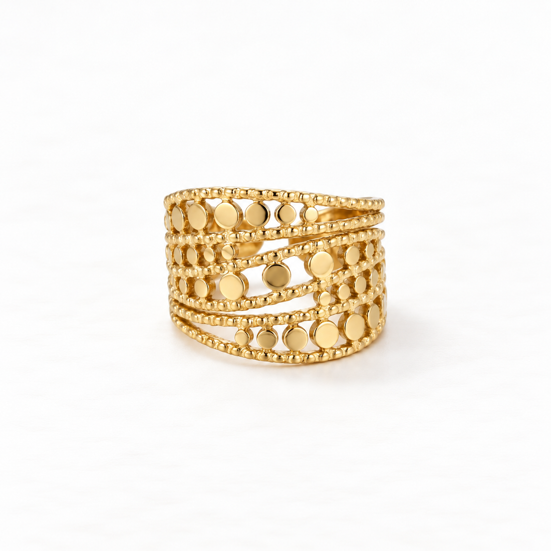 A gold wide band cutout ring with multiple rows of circular geometric cutouts and beaded edge details, openwork statement design, open adjustable band, shown from front and side angles on a clean white background displaying the intricate lattice pattern, substantial presence, and polished gold finish.